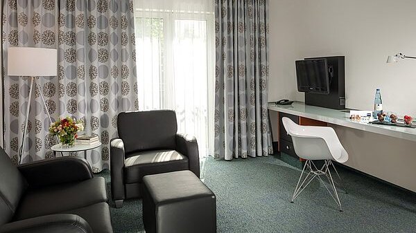 Ledercouch und Ledersessel und Schreibtisch im Hotel in Neuss
